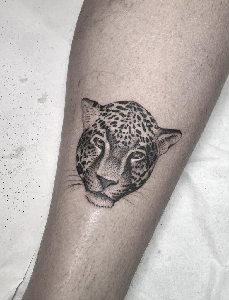 Tatuaje de cabeza de jaguar en blanco y negro con línea fina en estudio de tatuajes en Estepona.